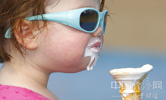 戴墨镜的小女孩在吃冰激凌。