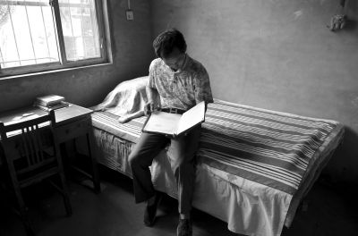 孟现杰在儿子生前的桌旁翻看孩子的物品