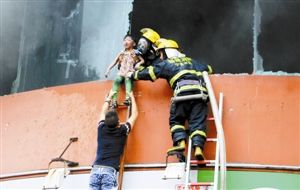 9月16日，福建宁德消防官兵和群众营救火灾现场的儿童。新华社 发
