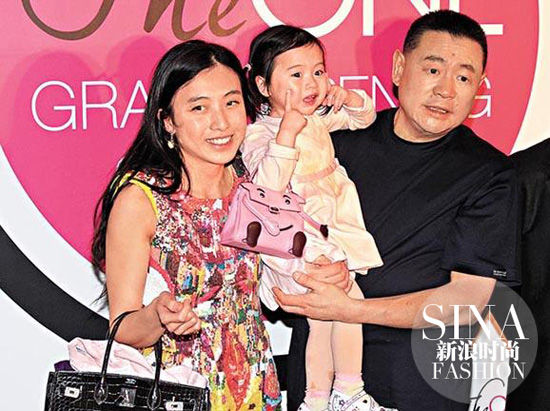 刘銮雄抱着女儿约瑟芬，旁边是妈妈甘比，约瑟芬手里挎着Kelly Doll小手袋