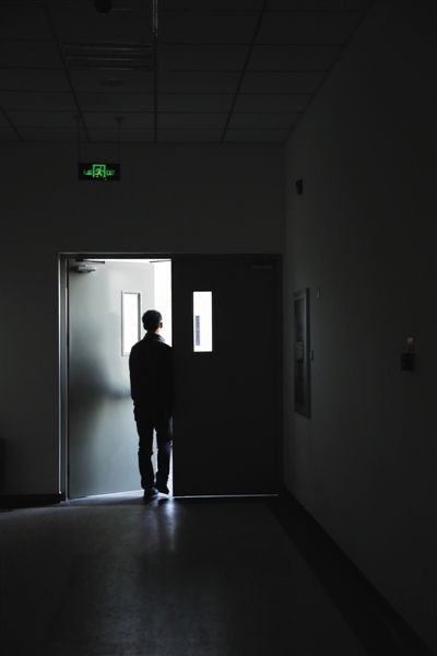 昨日，北京某高校教学楼的楼道里，艾滋病感染者李维推开通往室外的门。  摄影/新京报记者 卢淑婵