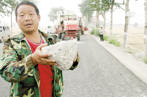 图为麦客向记者展示砸车的石头。