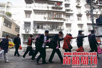 民警端掉传销窝点后，传销人员排着队去派出所接受调查，他们也与曾经在那里“奋斗”过的出租屋渐行渐远。