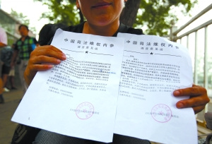 7月30日，一位上访者向记者展示她花500元买的“内参”。这样一份盖着红戳、署名为“《中国司法维权内参》编辑部”的“内参”，近日出现在北京南站附近的上访人群中。访民们称，只要花费几百元到数千元不等，“编辑部”就会派“记者”对访民的诉求展开调查，然后向地方甚至国家分管部委发“内参”，被反映问题的单位将因此解决问题。但据知情者称，所谓“内参”，只不过是有人冒用“维权机构”的名义和公章开具，骗取上访者的钱财。本报记者 孙纯霞 摄