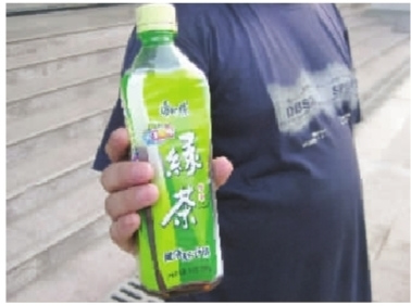 周先生拿着内含黄色不明沉淀物的半瓶康师傅绿茶。