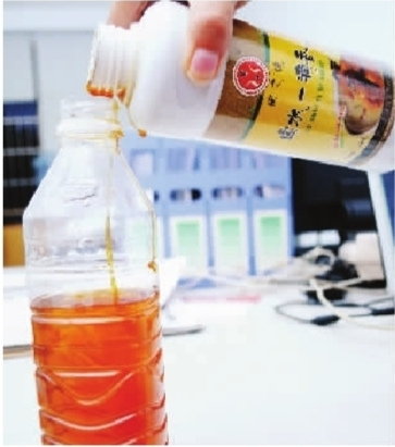 　　9月13日，记者倒了几滴“一滴香”进纯净水瓶里，水很快变成了黄色，还像油脂一样浓稠。 记者 童迪 摄