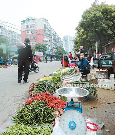 为省摊位费，菜贩将菜摆在马路边上卖。