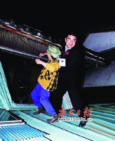 　　质疑照片二：3月中旬，陈光标在日本地震灾区救援中，将一名日本妇人从危房中救出来，遭网友批驳，称其生硬作秀。资料图片