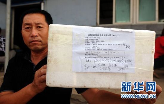 　　7月26日，河北省乐亭县扇贝养殖户张玉田在展示采集扇贝的证据封签，以作为将来索赔的证据。他们邀请天津一家海洋研究所的工程师和唐山市公证处工作人员共同采集了30箱这样的证据。　新华社记者巩志宏摄