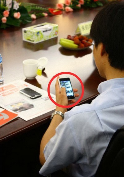 图为雷军在使用魅族M9手机 图片来源：新浪微博