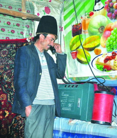 阿不都拉·努尔在用卫星电话联系卖羊，他期望能在古尔邦节前卖个好价钱。