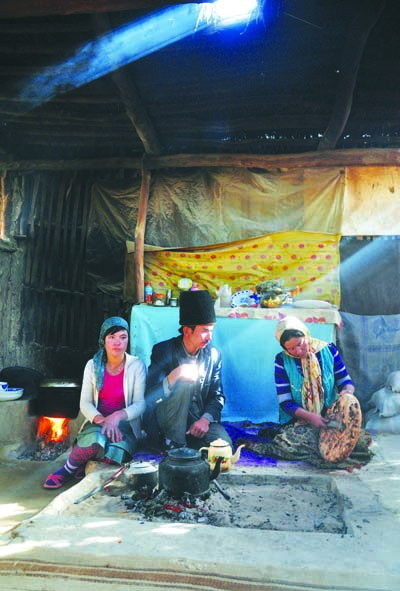 阿不都拉·努尔和妻子再娜甫汗在烤制“库麦其”。