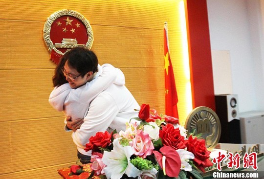  2011年2月14日，河南郑州一对刚刚领到结婚证的新人兴奋的拥抱在一起。