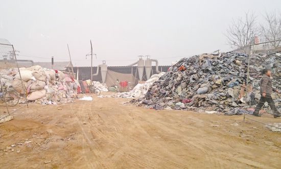 图为河北保定博野县白塔村一“开花”厂内，左边堆着浅色旧衣服，右边堆着深色旧衣服