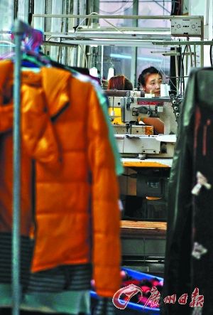 其中一家颇具规模的小作坊内，工人正在缝纫机前工作。