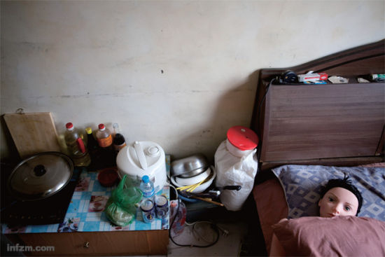 　　北京五环外一幢临时建筑里，李坤(化名)将充气娃娃安放在自己的单人床上。简陋的小屋里，“她”是他惟一的伴。 (南方周末记者 张涛/图)