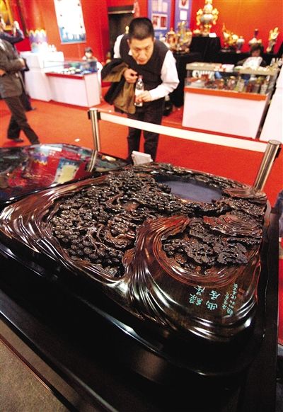 　　2010年，在“第十一届中国工艺美术大师作品暨国际艺术精品博览会”上，观众正在欣赏一方价值400万元的金丝楠木雕漆砂砚。施健学 摄