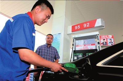 加油站工作人员为车主加92号新油。中石化供图 