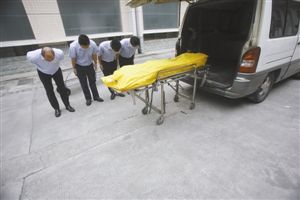 运送遗体的人员向遗体致敬。