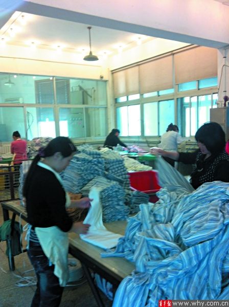 洗衣作坊里叠衣服的女工全都着便服、赤手上阵。本版摄影 记者 贺佳颖