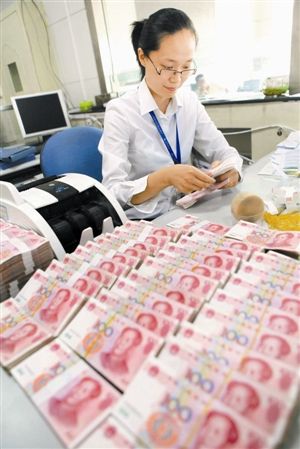 时隔不足一月，央行两次降息。图为江苏省赣榆县农村商业银行营业员在清点人民币。 新华社发