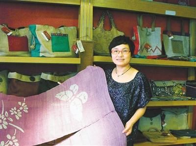 綦涛在位于洪崖洞的店铺内，展示用夏布做的门帘。 记者 兰世秋摄