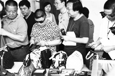 竞拍人在拍卖前实地看样，标的物中包括爱马仕、夏奈尔、GUCCI等名牌包、皮带。