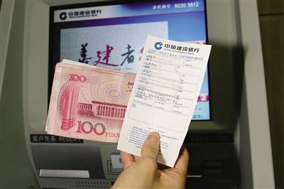 昨日，建行工作人员演示ATM取款打印钞票冠字码。