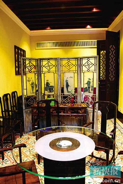 客厅中间是一张古色古香的红门圆桌，配上酸枝嵌云石板玫瑰。