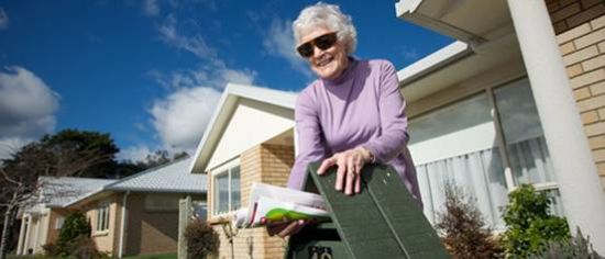 奥克兰北部退休村，一位老人在从自己的信箱里取信。