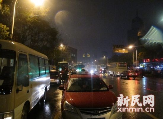 　　图说：3月23日20时40分，正对东方明珠2号门的路边停着一排空车，不少驾驶员聚在一起聊天。  新民网记者 胡彦珣 现场回传