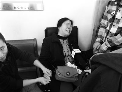 　　昨日下午，兴业银行北京海淀支行，卖房人何女士痛哭昏厥，一旁的记者赶紧掐其手背虎口施救。新京报记者 张太凌 摄