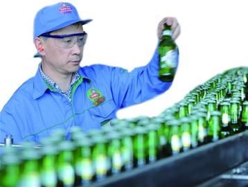 王振竹在啤酒包装线旁检查瓶装啤酒外包装质量