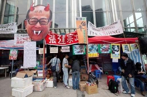 李嘉诚的照片被画上魔鬼的红色双角和白色獠牙，额头上写着“奸商”两字。