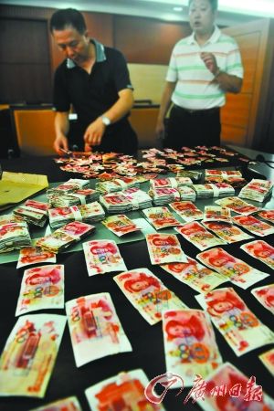 　银行工作人员鉴别真假钞后，按规定兑换。