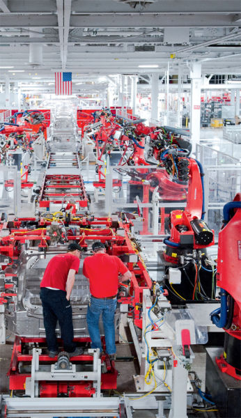 生产线上一排排机器人手臂代替了人工，大部分机器人由德国KUKA提供