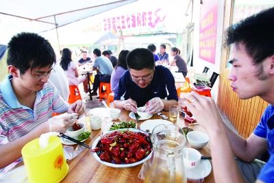 虽然环境一般，路边龙虾店生意依旧火爆。(资料图片) 记者詹松 摄