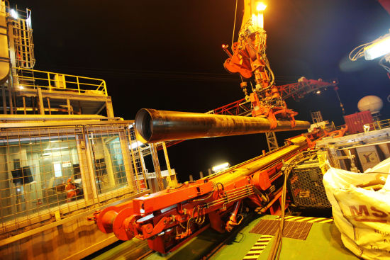 机器抓手抓着套管放到猫道机上，然后由猫道机滑动送向钻台