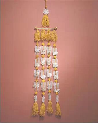 玉组佩 　　明晚期，通长53.6cm，清宫旧藏。组佩由53件玉饰串成。上部以一件寿星骑鹤式玉纽总揽组佩，其下有金质横梁，横梁两端为龙头。横梁下悬有4串玉片，每串由上下5组构成，横向相对。