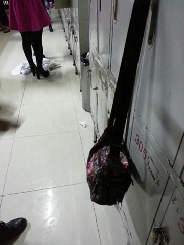 图为在更衣间工作人员直接将工作服扔在地上，随意踩踏