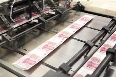 印钞公司车间，一沓沓人民币在机器上被裁切成型。 燕平 摄