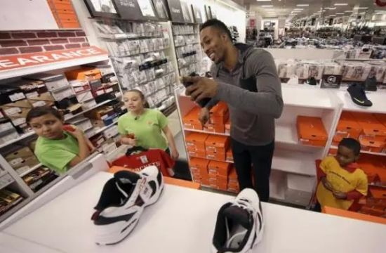 2015年12月1日，在休斯敦，火箭中锋德怀特-霍华德，与休斯顿救世军具乐部的孩子们一起购圣诞礼物，目的是让孩子们有一个特殊的节日购物体验。图片来源：AP