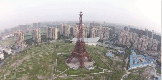 于2001年就拿到7000亩地的广厦杭州天都城，目前开发体量仅仅只有总规划的一半左右。图为高108米、3:1比例建造的山寨版“埃菲尔铁塔”至今依然屹立菜地中央。