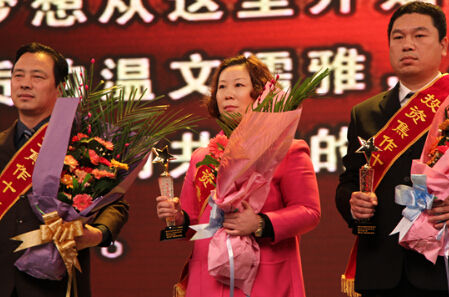 2012年9月，廉金枝（中）高票当选“投资焦作十大风云人物”。    资料图