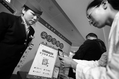 西苑医院服务台人员在介绍和帮助患者使用支付宝挂号。摄/法制晚报记者 林晖