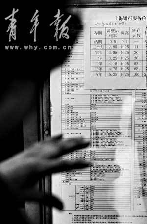 　　一位市民正在银行查看调整后的利率。