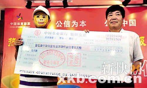 　　■大奖得主戴孙悟空面具手持大奖支票留影。