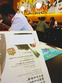 　　菜谱上关于钙含量的说明已被白纸遮盖。(张定业 摄)