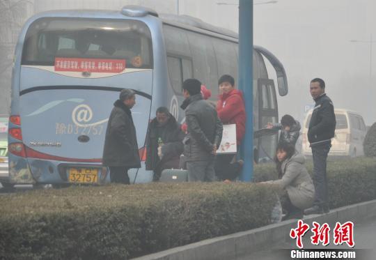 一辆长途客车在站外为乘客装行李。