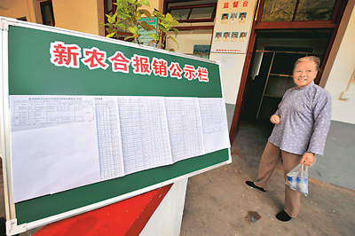 在福建省松溪县祖墩乡溪后村医疗卫生服务中心点，一名农妇经过新农合报销公示栏。